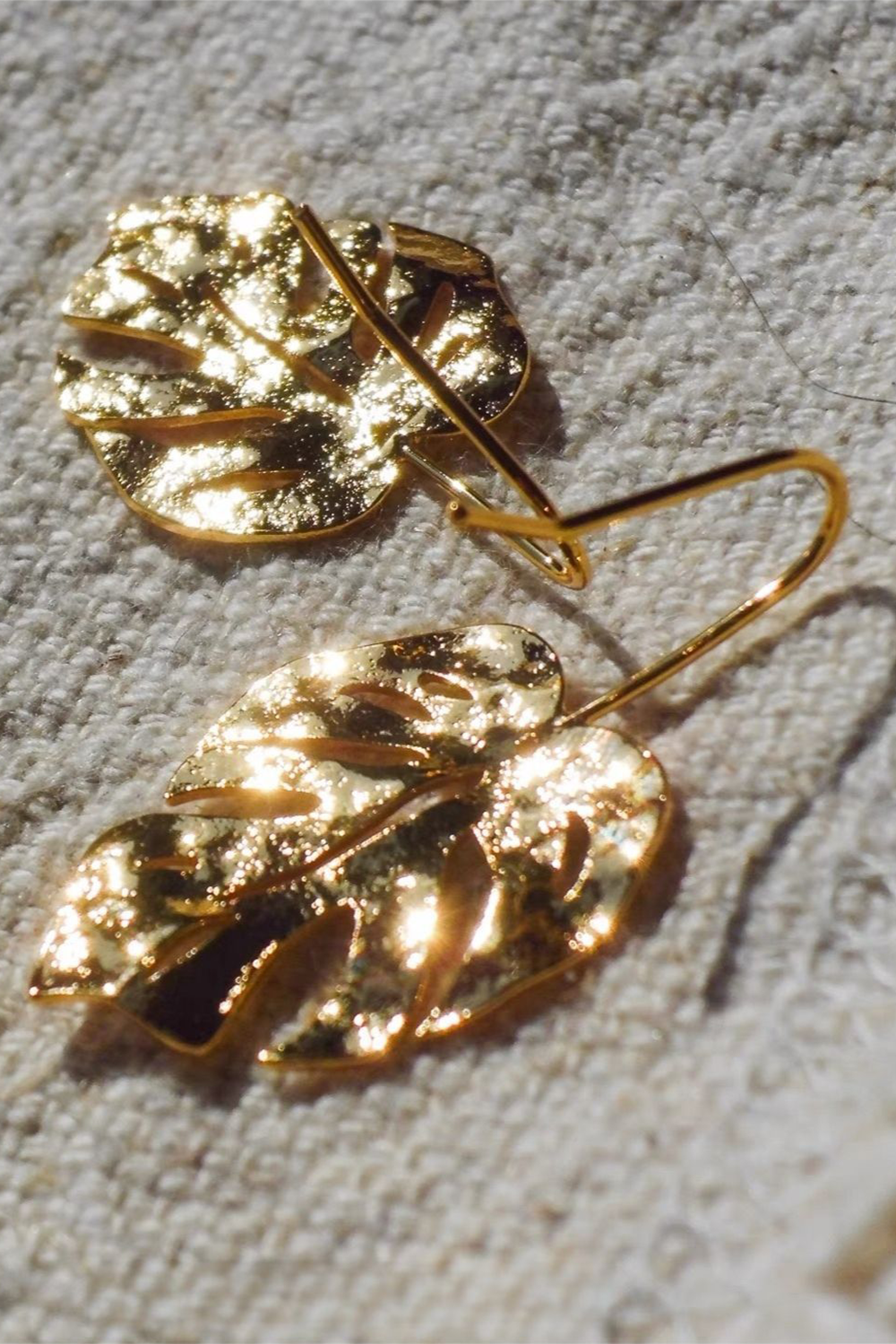 Monstera leaf earrings on linen - Light catching engraved veins