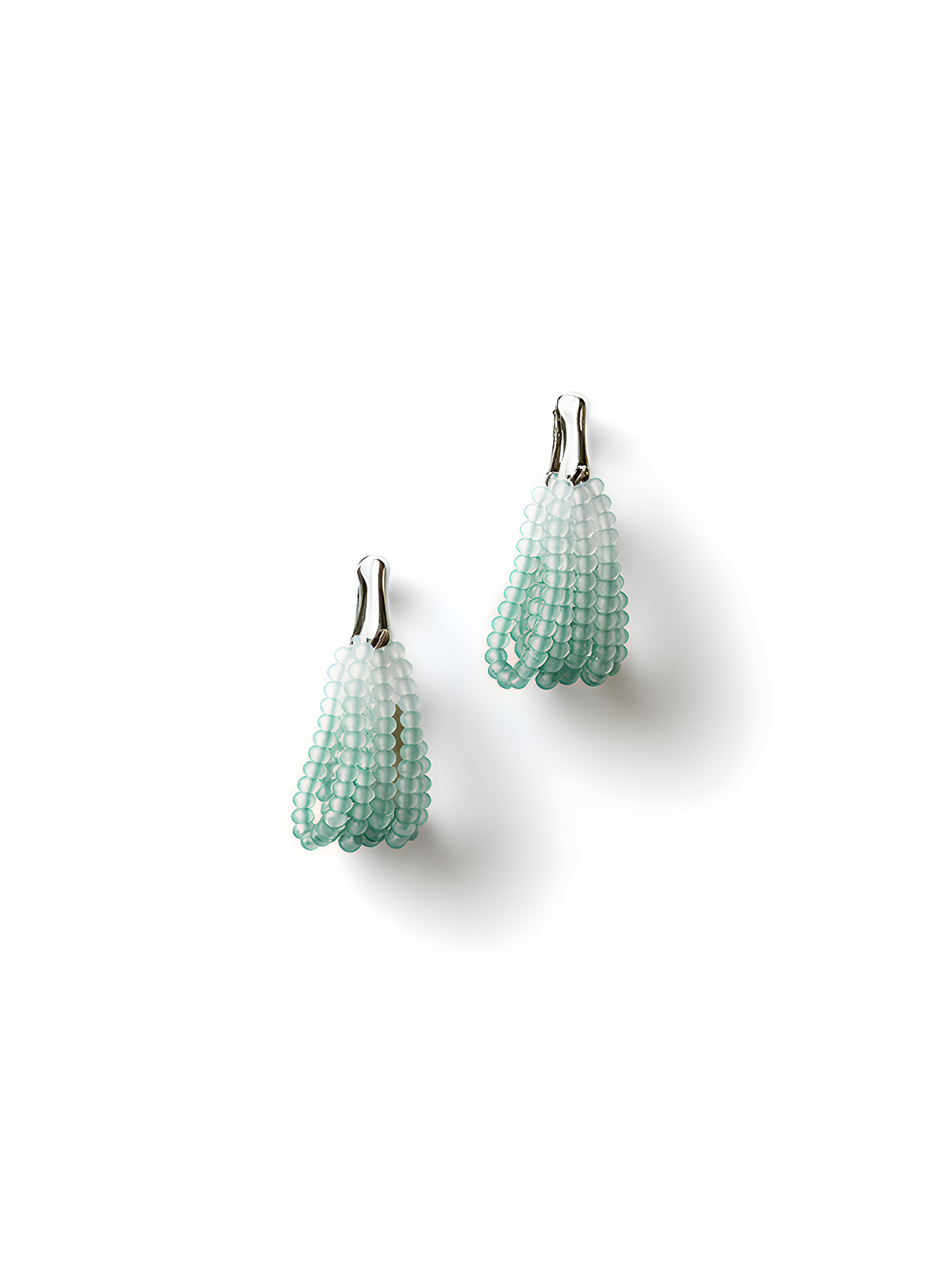 Pair of aqua to white gradient beaded drop earrings with silver hooks, laid flat on a clean white background.