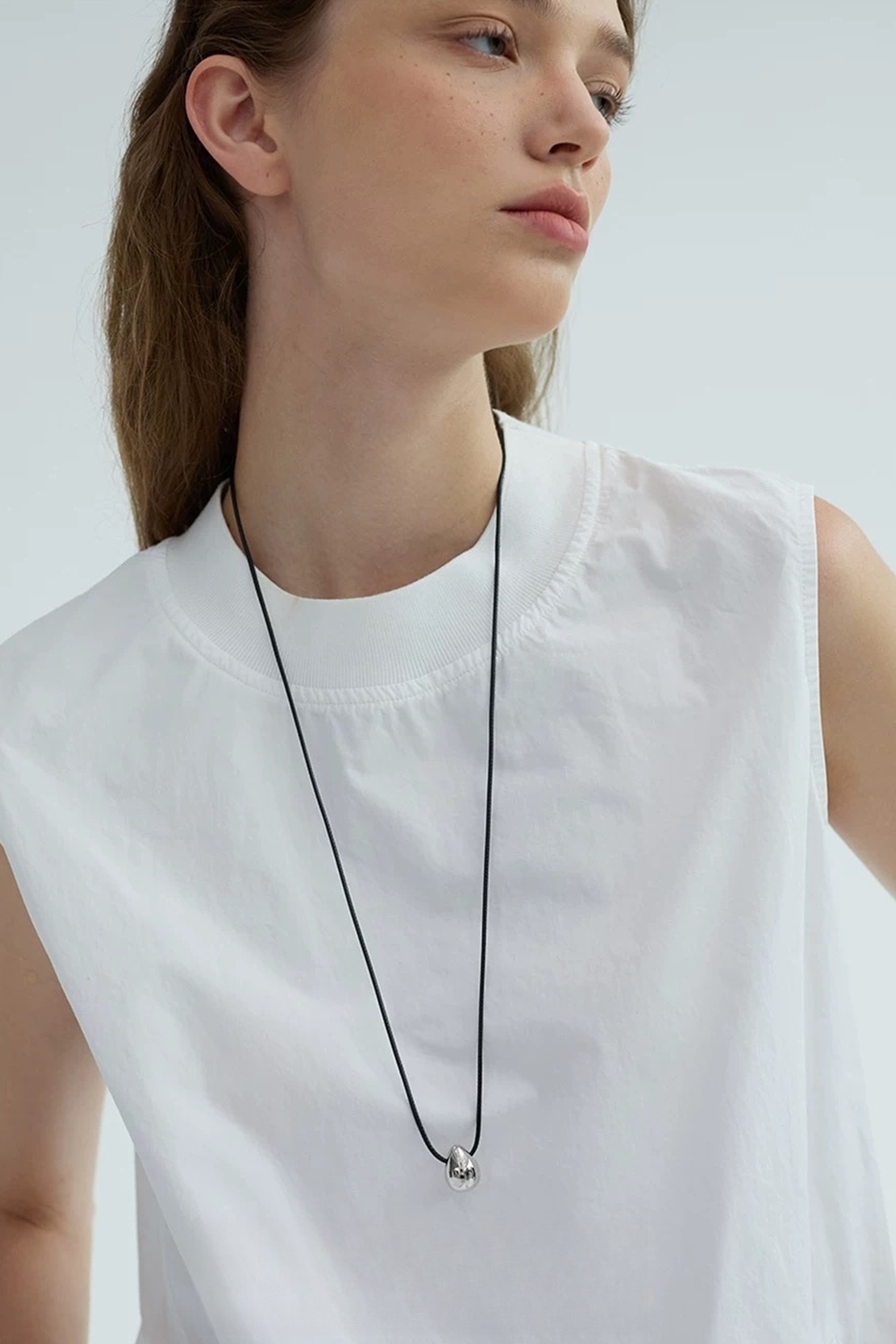 Black Cord & Silver Teardrop Gleaming Against Fair Skin | Seysage