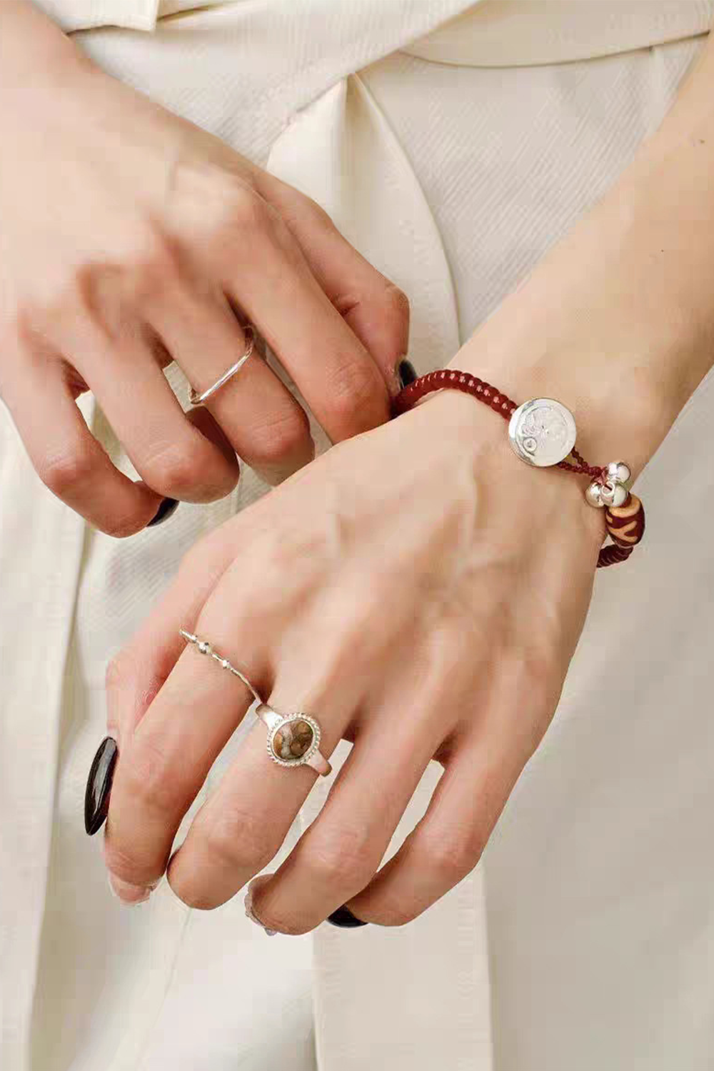 Cinnamon Braided Cord Bracelet Layered with Silver Rings on Crossed Hands | Seysage