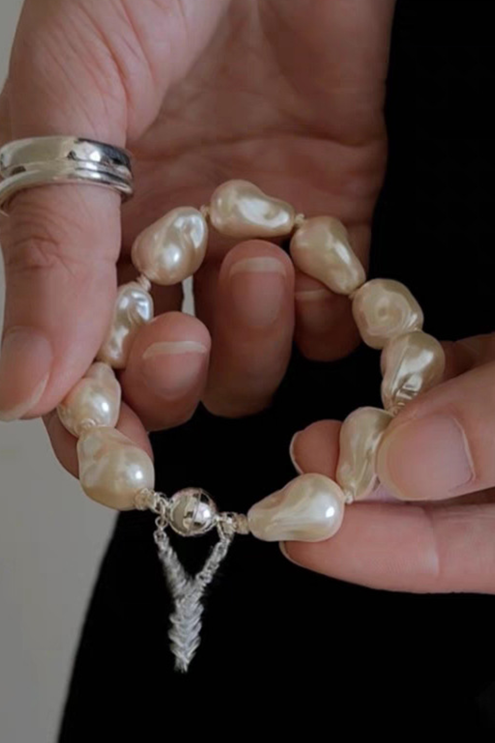 Ombre Baroque Pearls & Silver Plume Clasp Draped Over Hands | Seysage