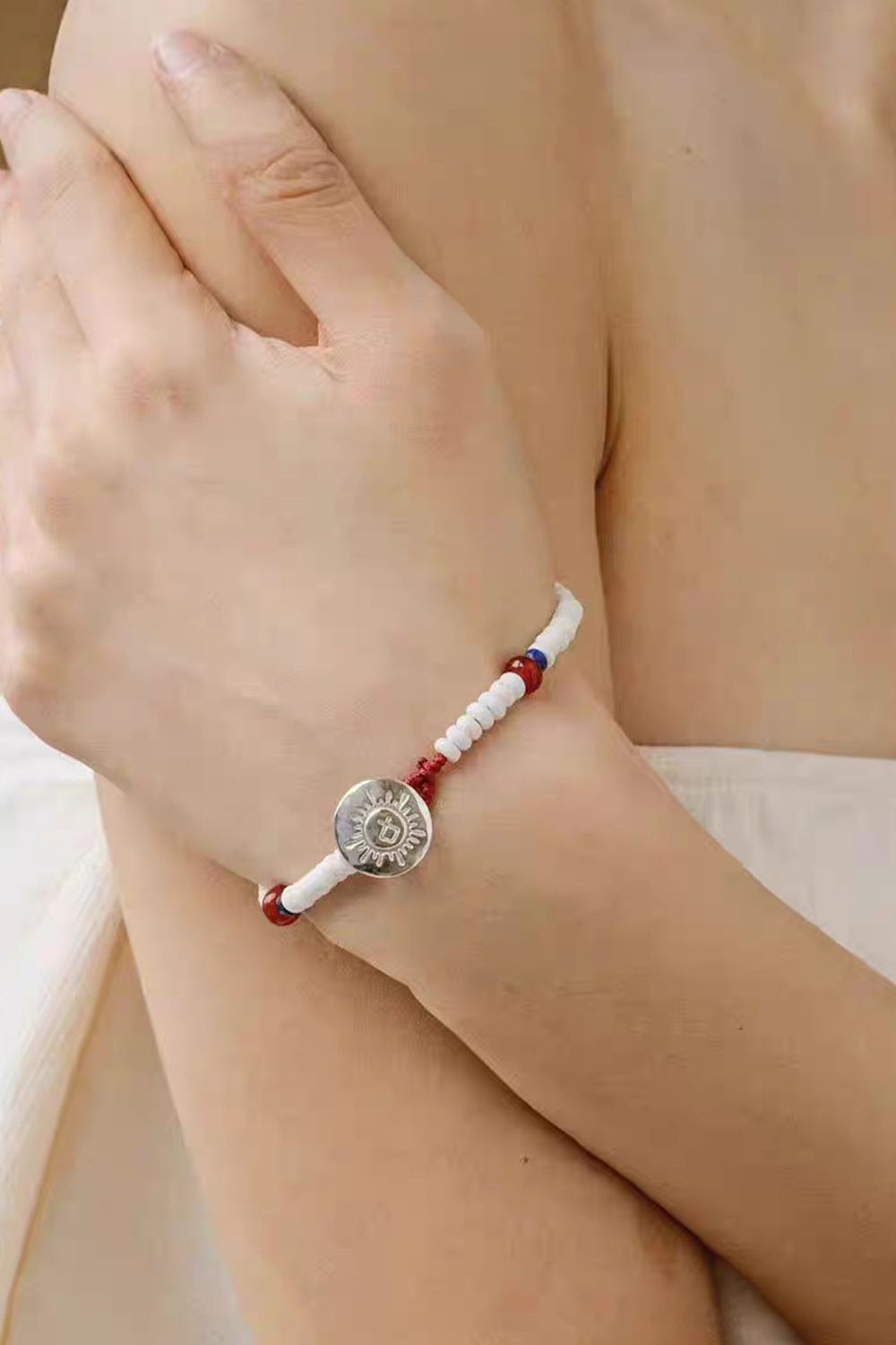 Porcelain Bead Bracelet with Sun Medallion Clasping Model's Wrist | Seysage