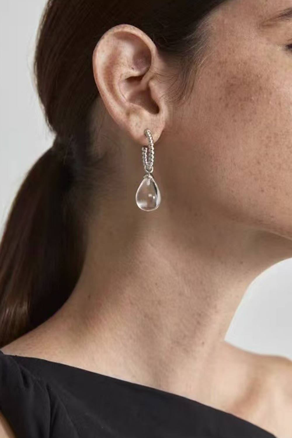 Natural quartz drop earrings on woman - Freckled skin & black top