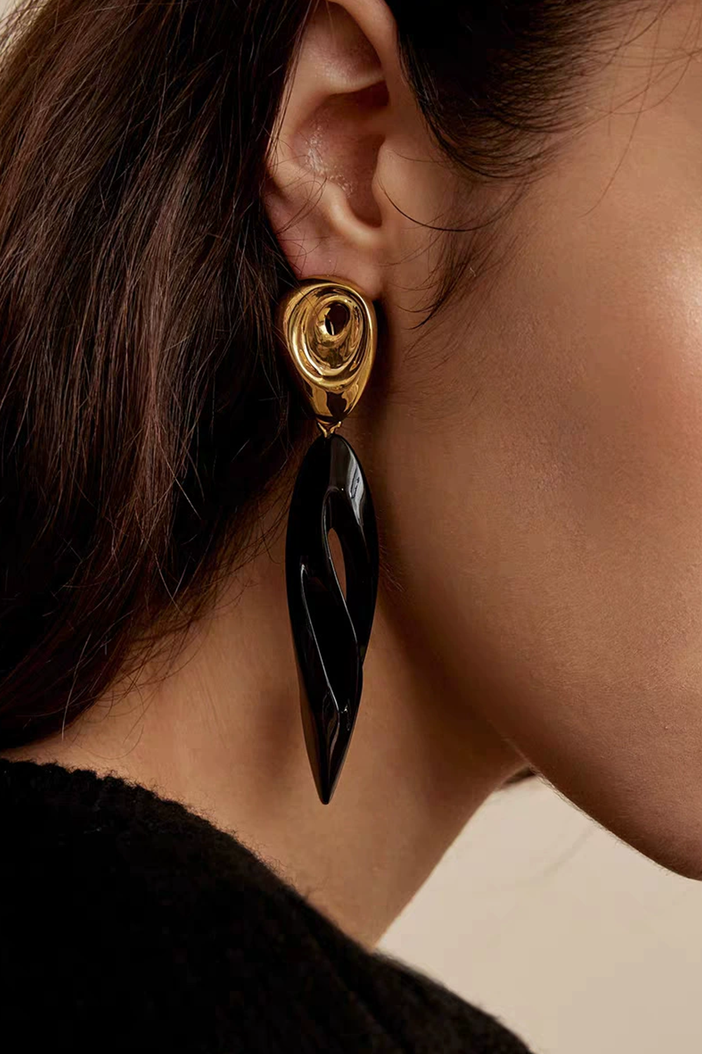 Close-up: Gold spiral hook with black drop on earlobe - Hypoallergenic art jewelry​