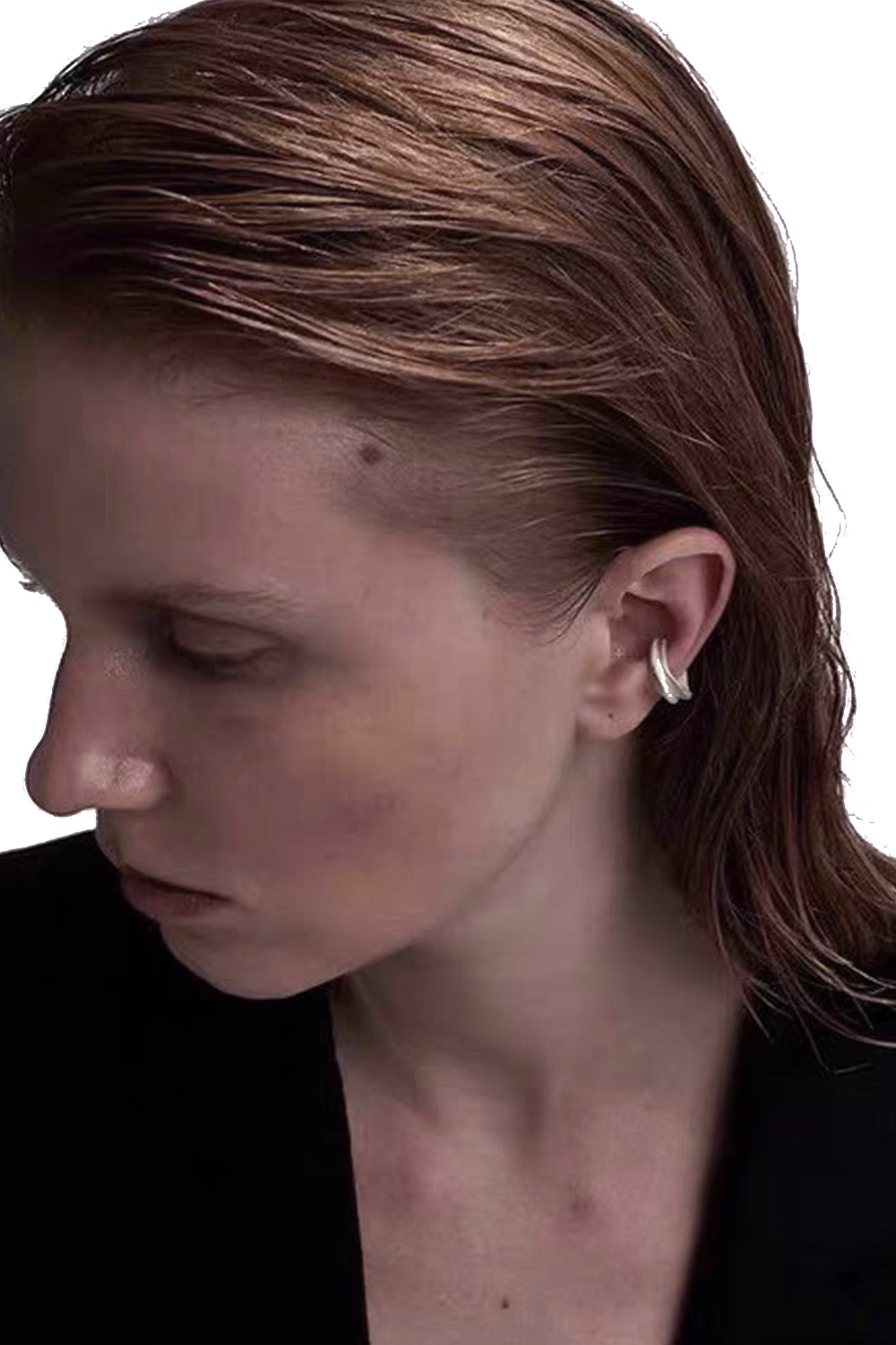 Matte silver ear cuff close-up on ear - Wavy black hair contrast in B&W photo