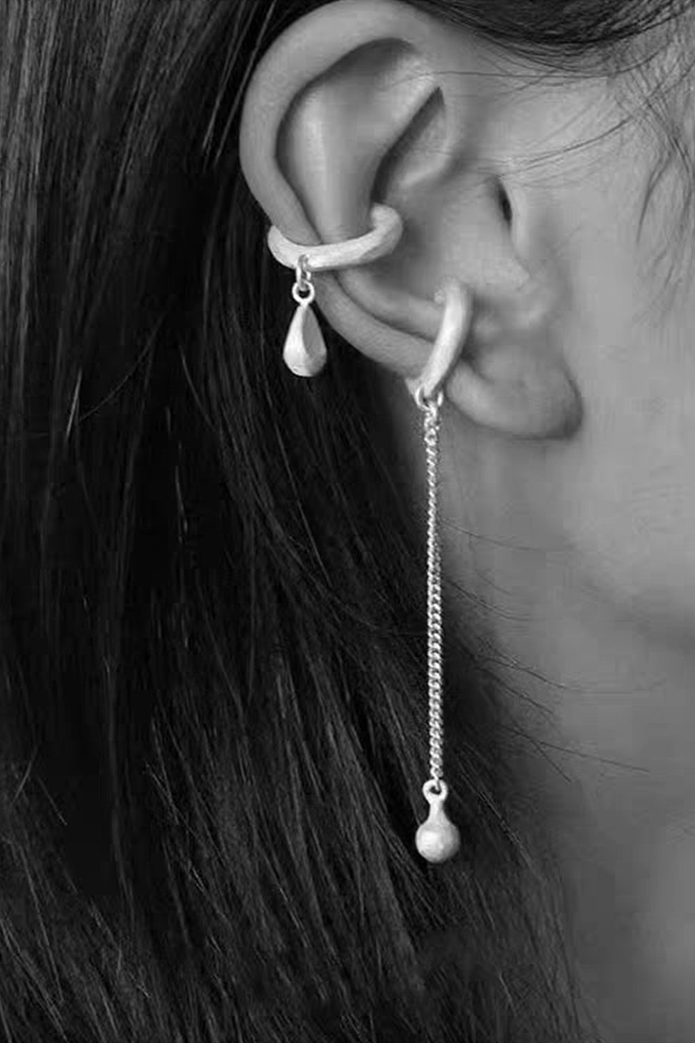 Double ear cuff close-up: Textured arc + spherical drop on dark hair