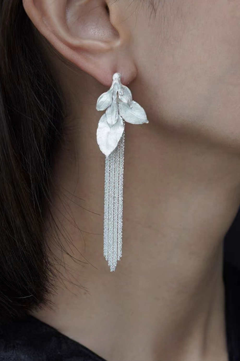 Silver leaf chain earrings on brunette - Side neck curve & blurred background