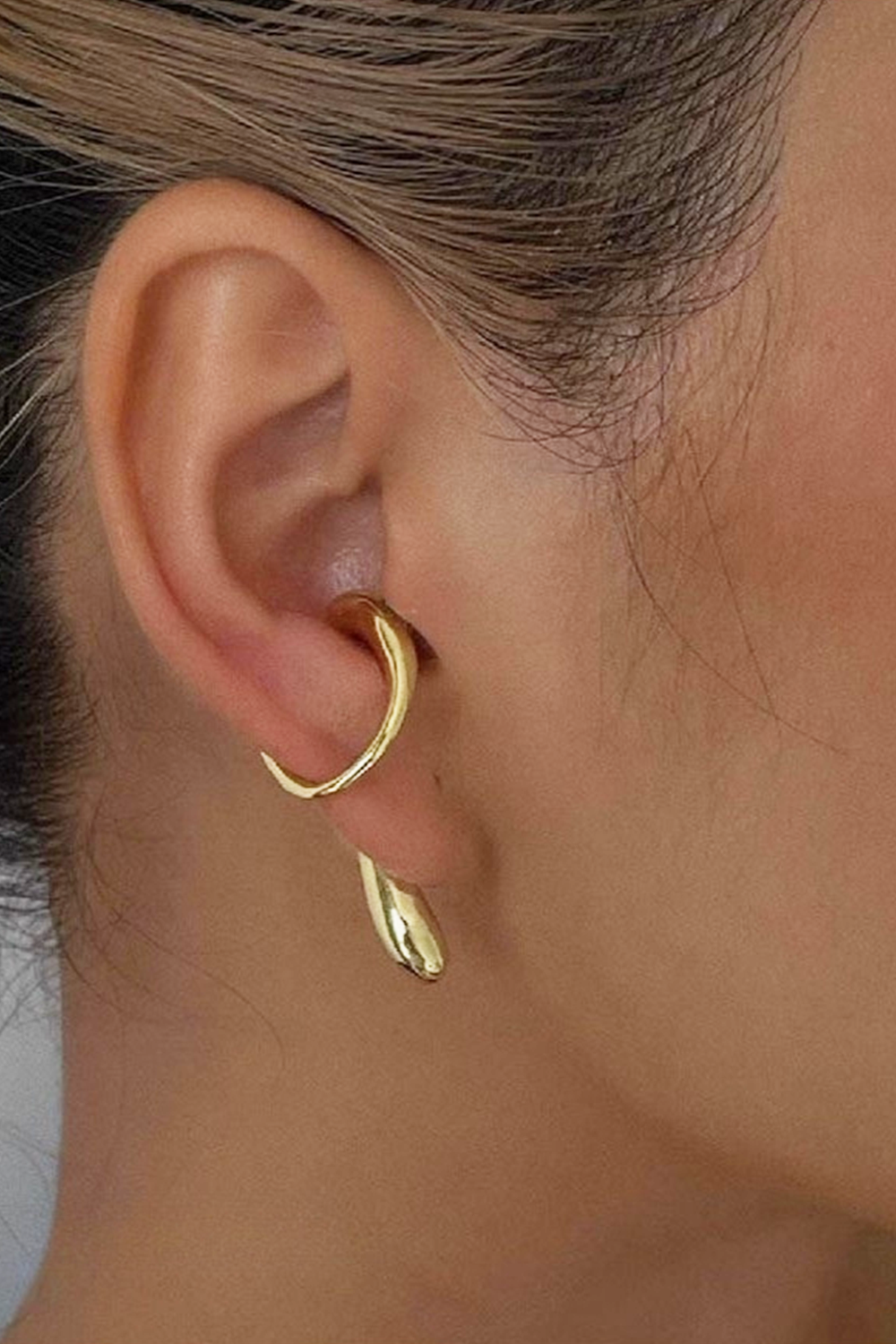 Gold ear cuff with fluid curve design on conch - Blonde hair & natural skin tone