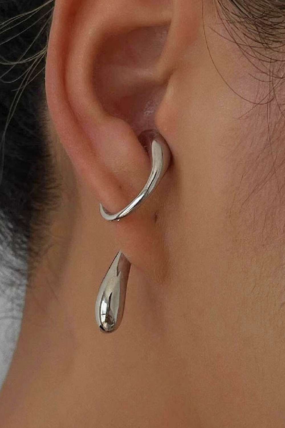 Silver fluid curve ear cuff on helix + teardrop charm - Dark hair contrast