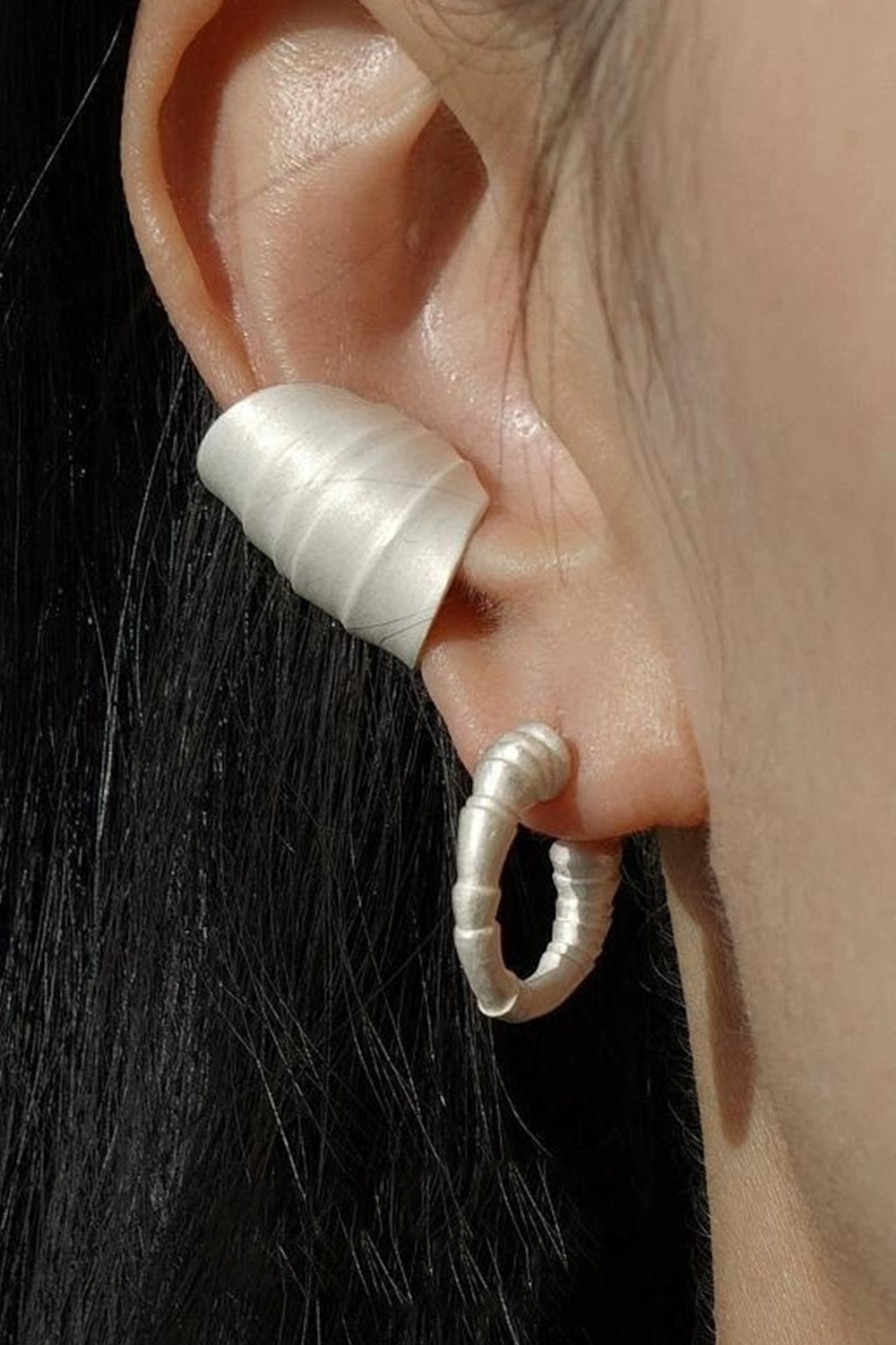 Textured wave ear cuff + stacked hoop earrings on ear - Dark hair contrast