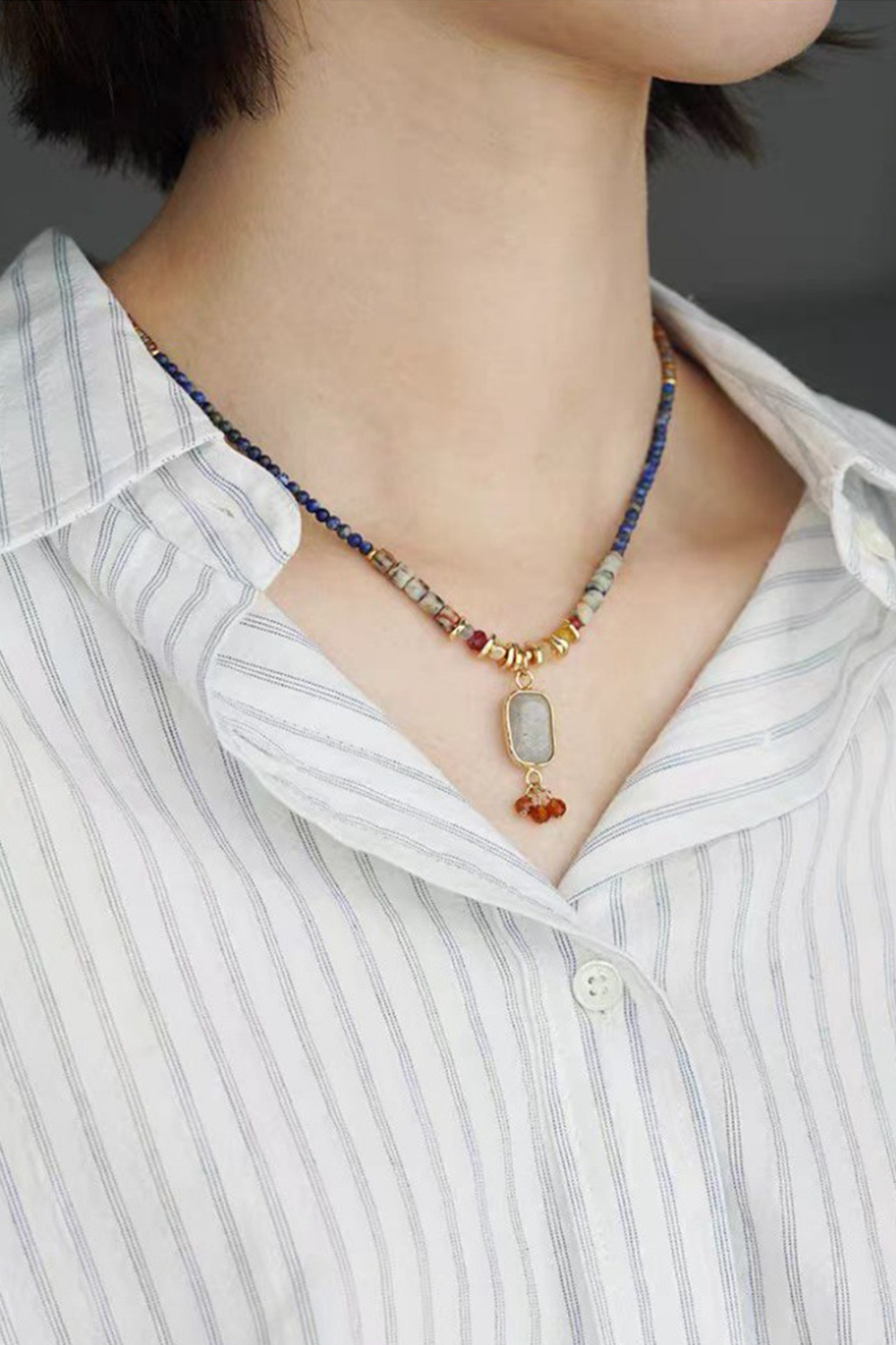 Textured Tribal Pendant Necklace Glowing Against Navy Stripes | Seysage