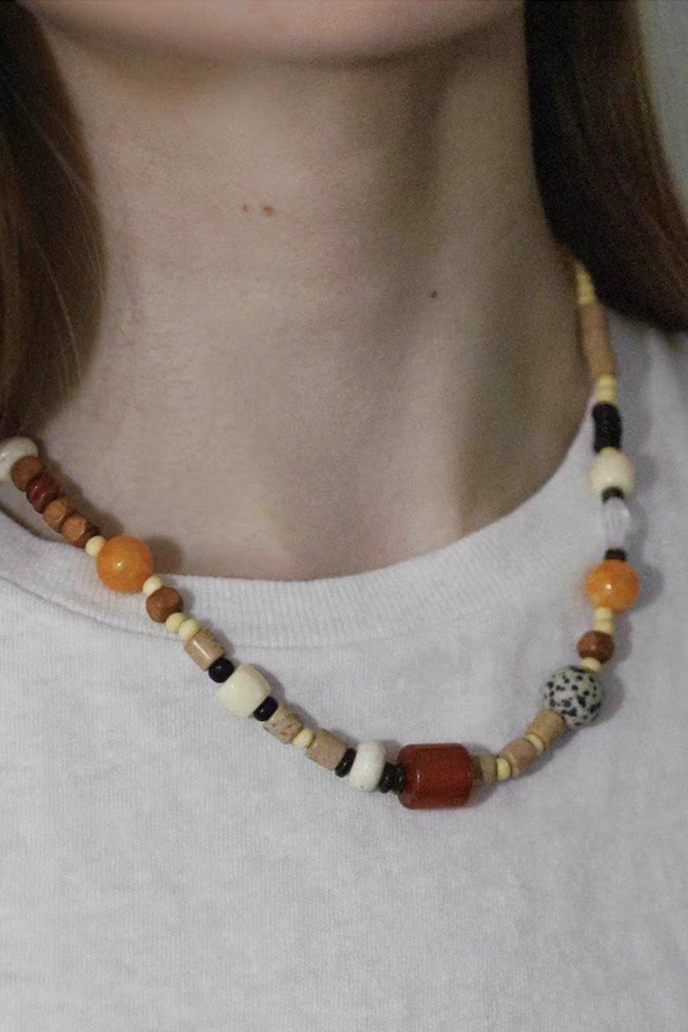 Warm-Hued Textured Beads Glowing Against Gray Teardrop Neckline | Seysage